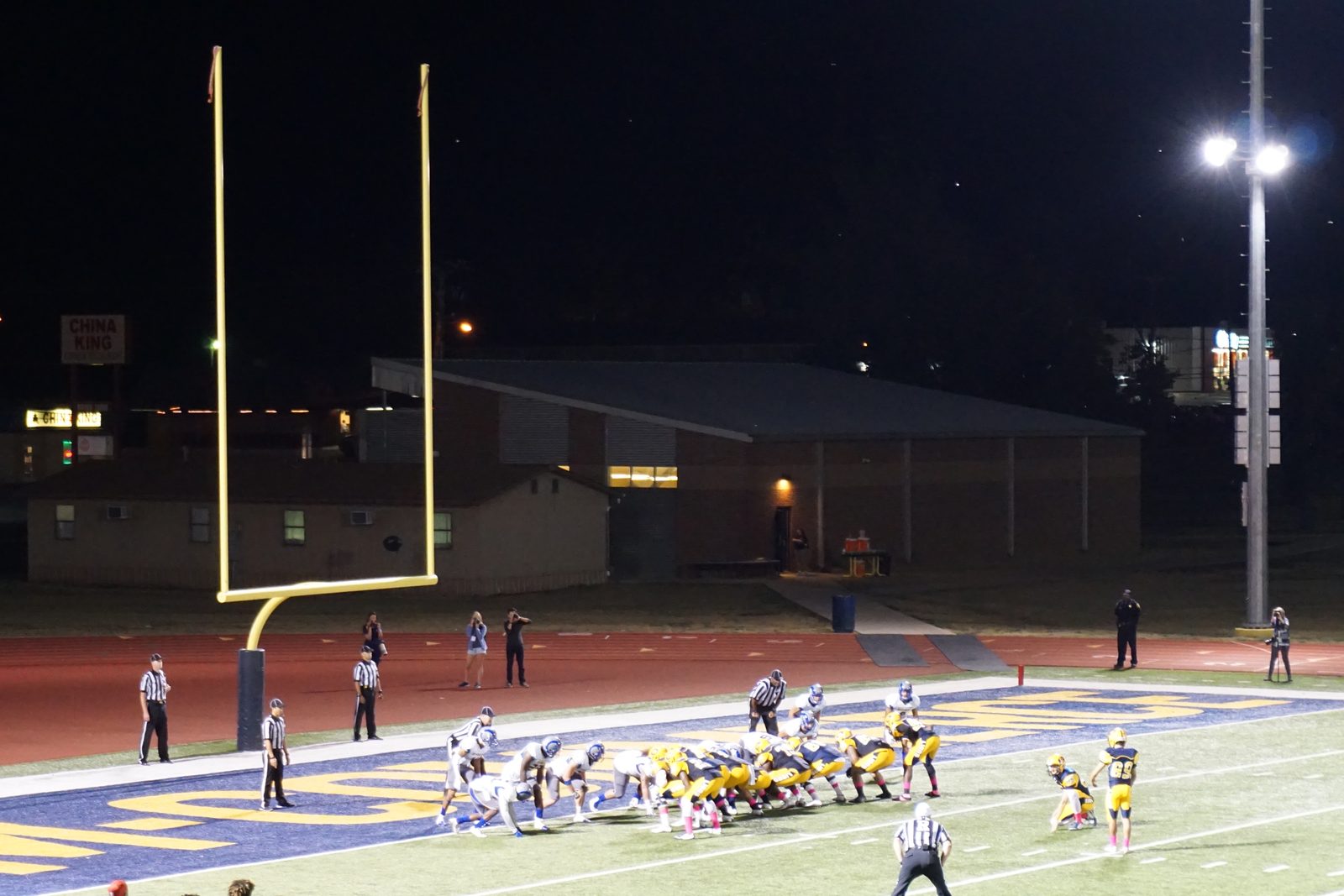 A field goal attempt under stadium lights during a night football game
