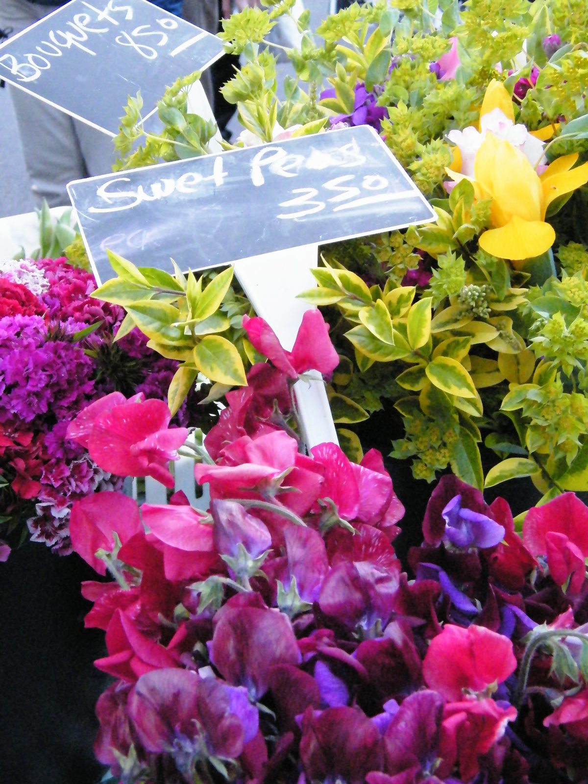 Fresh-cut flowers with hand-lettered signs at the Sonoma Farmers' Market in Sonoma, California. Reviewers called Solvang's market a "unique stop" where visitors experience the market and the town together.