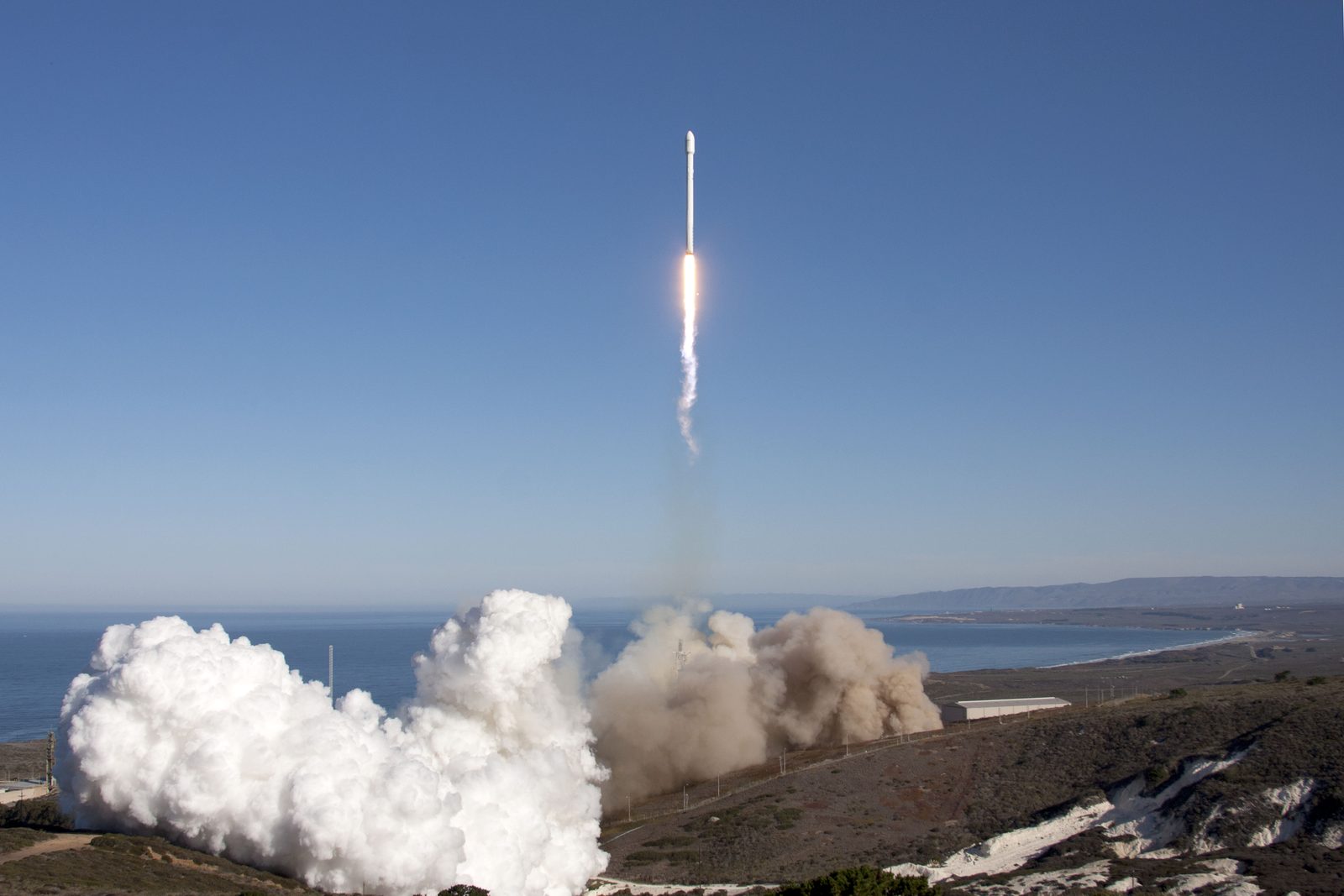 A Falcon 9 lifts off from Space Launch Complex 4-East at Vandenberg with the CASSIOPE satellite in September 2013. Today's flight follows a southern trajectory out over the ocean.
